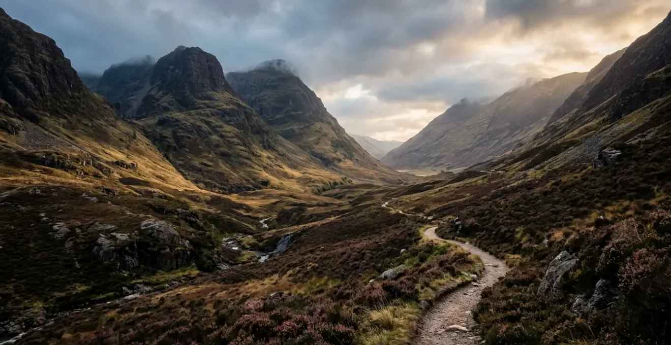 Misty Scottish Highland glen with winding path through dramatic mountain landscape at golden hour
