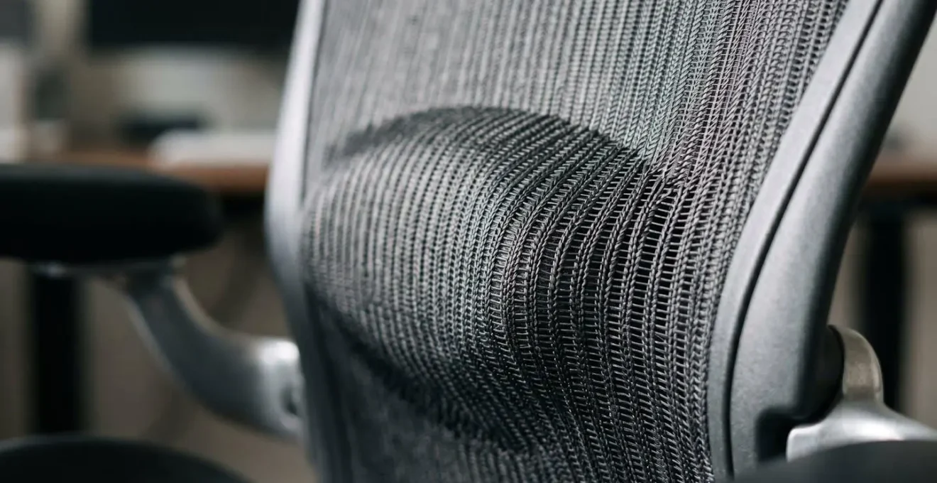 Close-up macro detail of ergonomic mesh office chair backrest showing advanced lumbar support structure